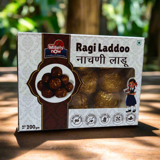 Box of Ragi Ladoo with Millets Now branding on a wooden surface.